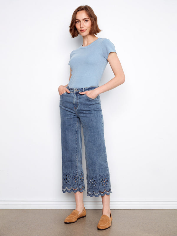 These stylish denim pants feature five pockets and an elegant scalloped eyelet hem, combining practicality with fashion by Charlie B.