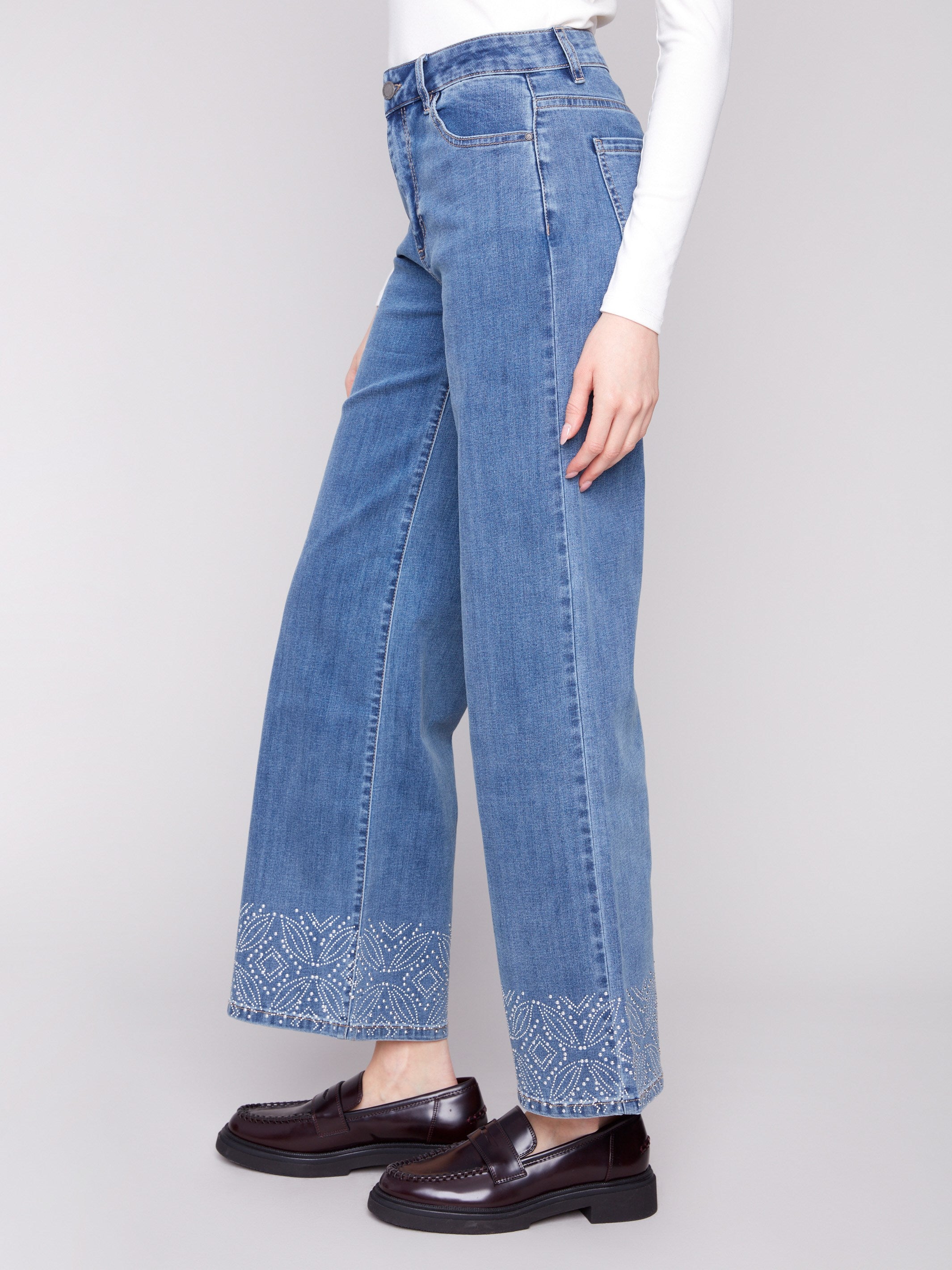 Stylish five-pocket design in medium blue denim with detailed patterned studs, offering a flattering fit by Charlie B.