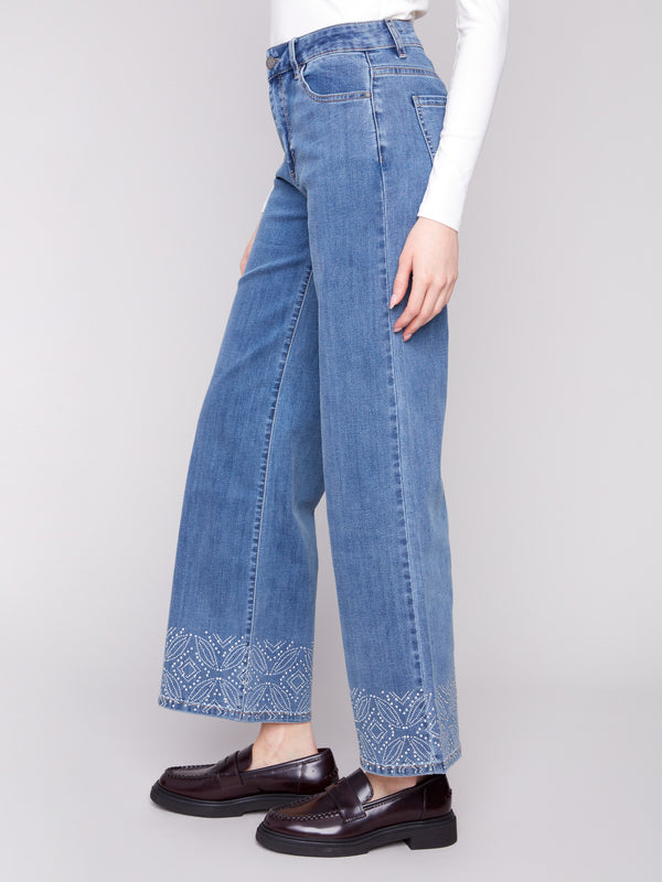 Stylish five-pocket design in medium blue denim with detailed patterned studs, offering a flattering fit by Charlie B.