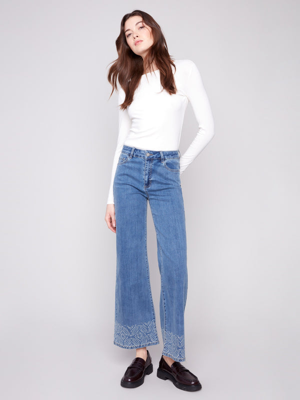 Regular rise medium blue jeans with artistic patterned studs at the hem, perfect for versatile styling by Charlie B.